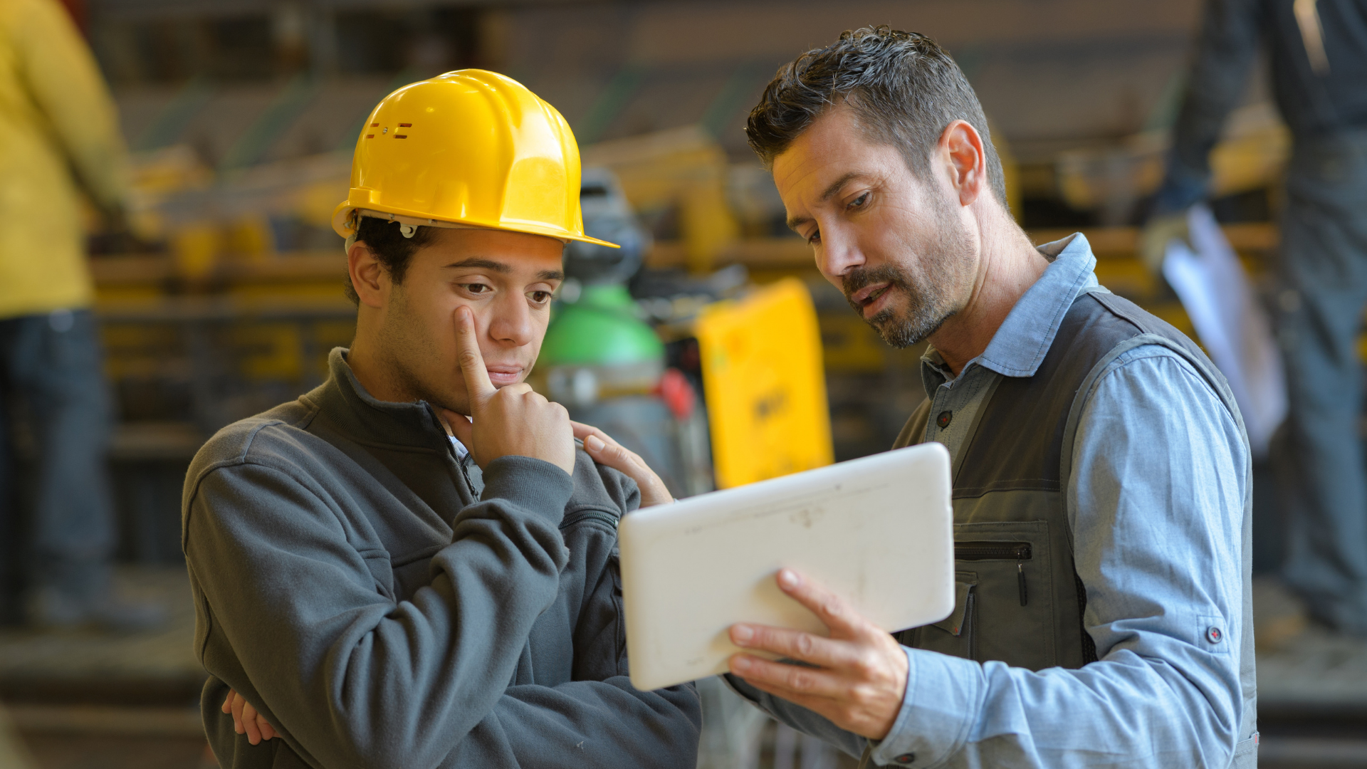Two construction workers viewing information on a tablet