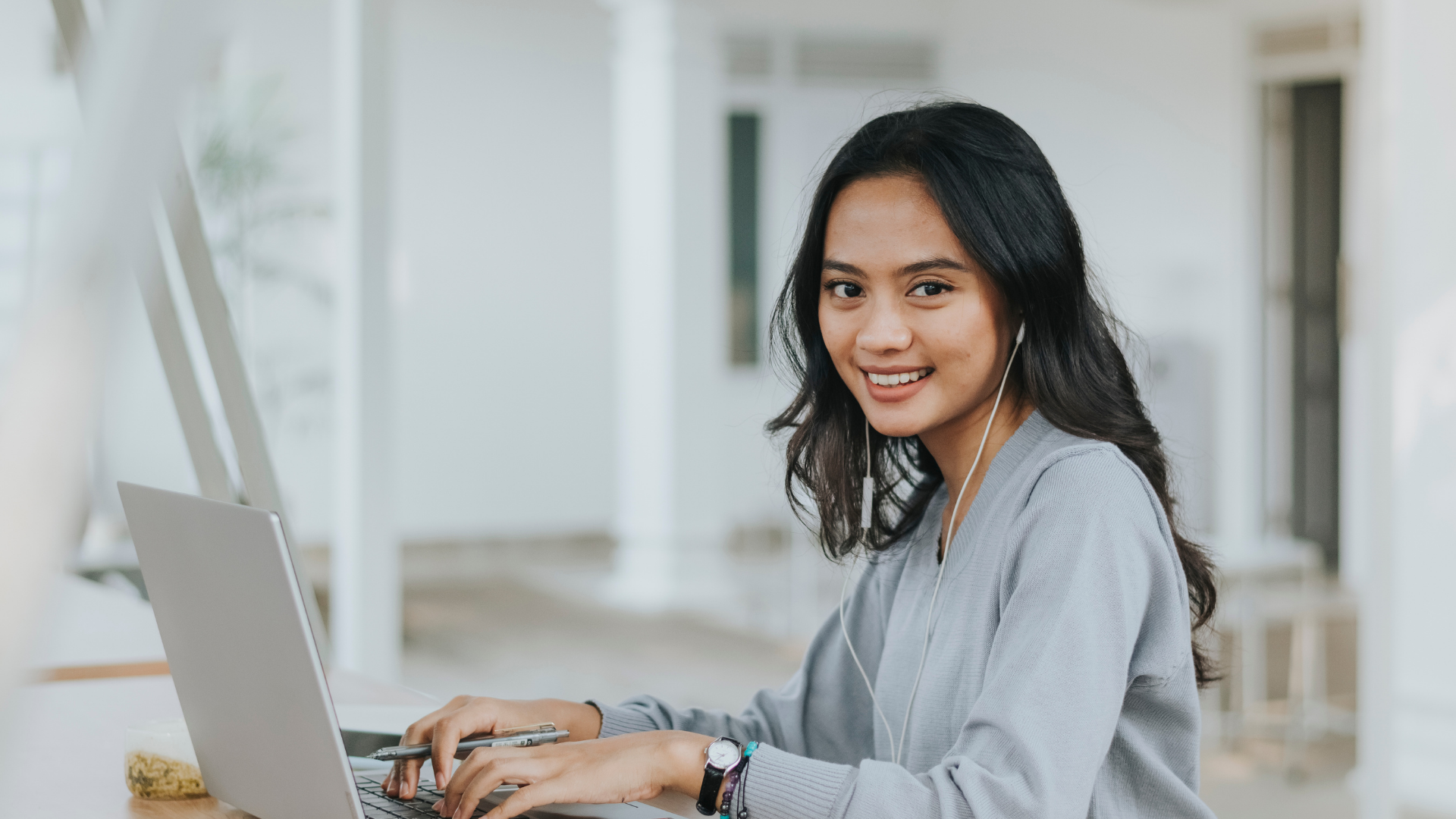 A female employee smiling, working on her laptop