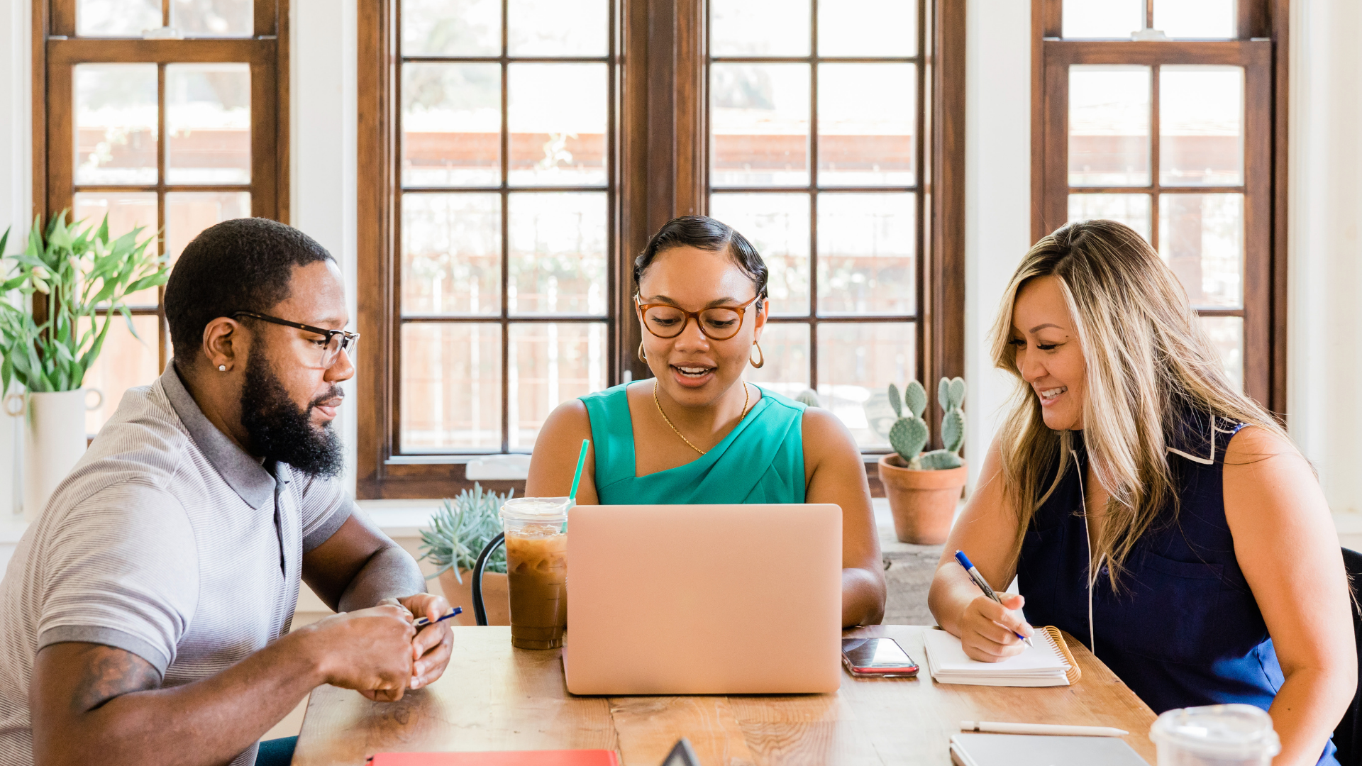 Woman showing co-workers information on her laptop in an office space