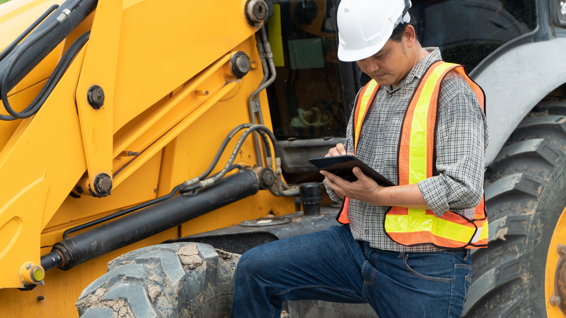 Construction worker on site writing on his tablet