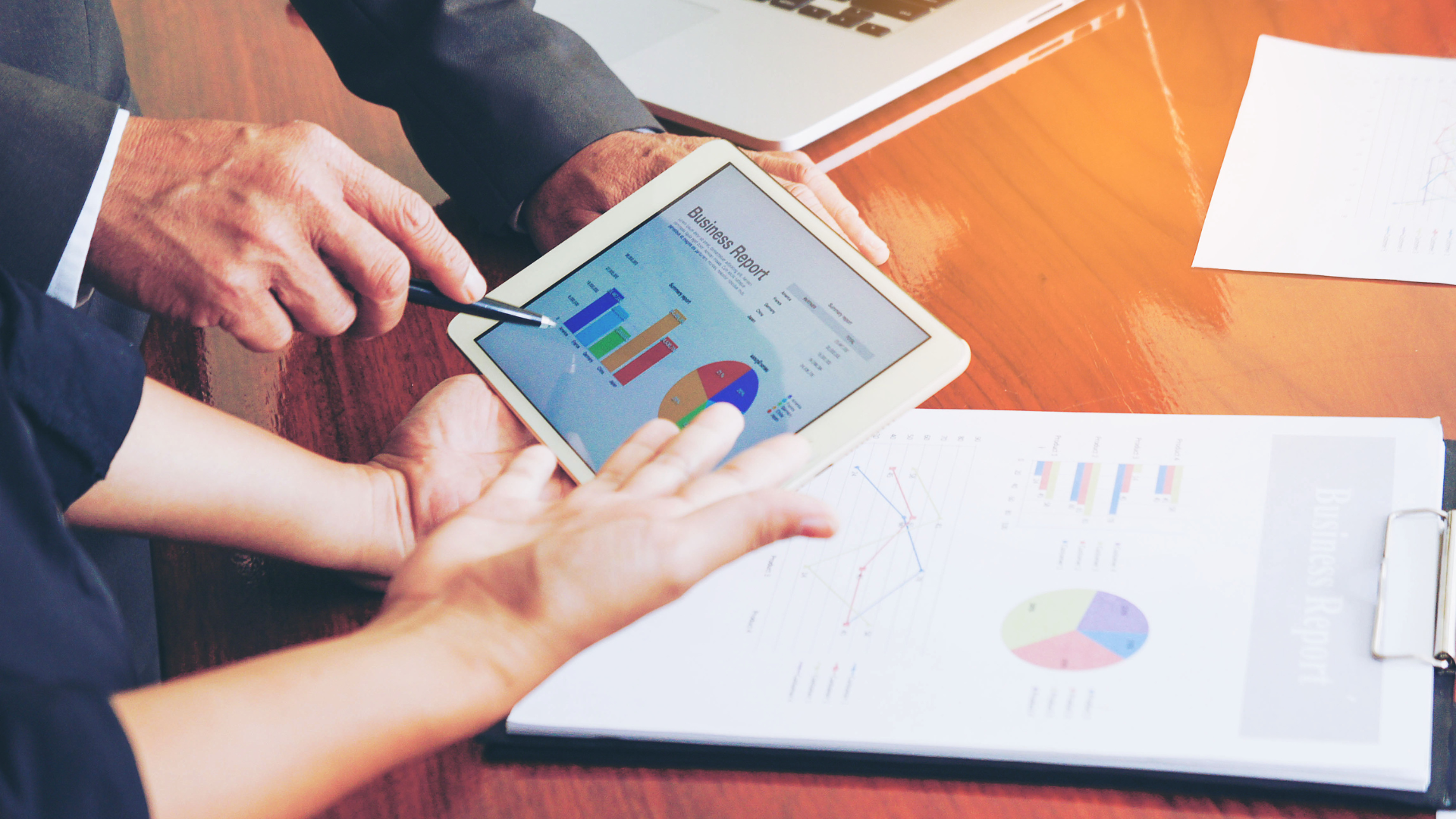 Employees looking at data and business report on a tablet