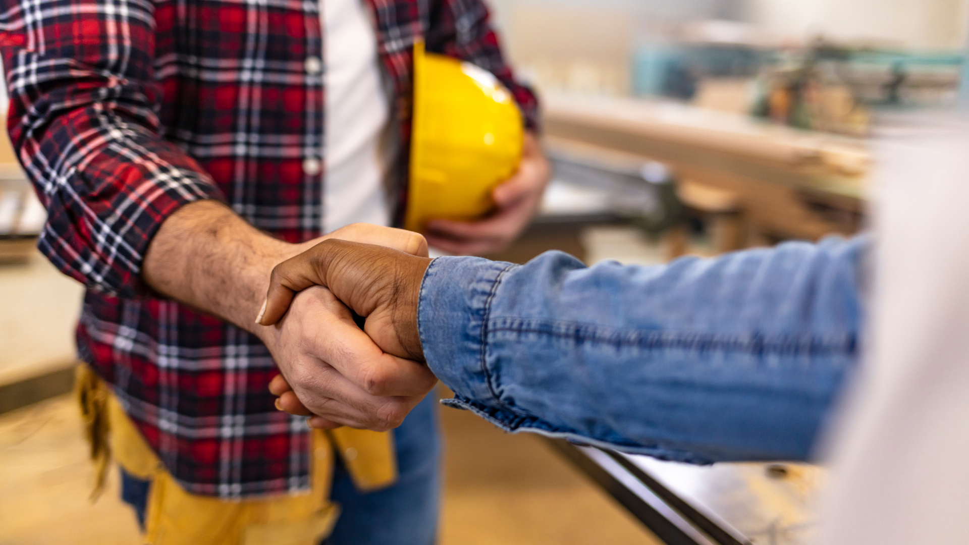 Two people shaking hands at a work site