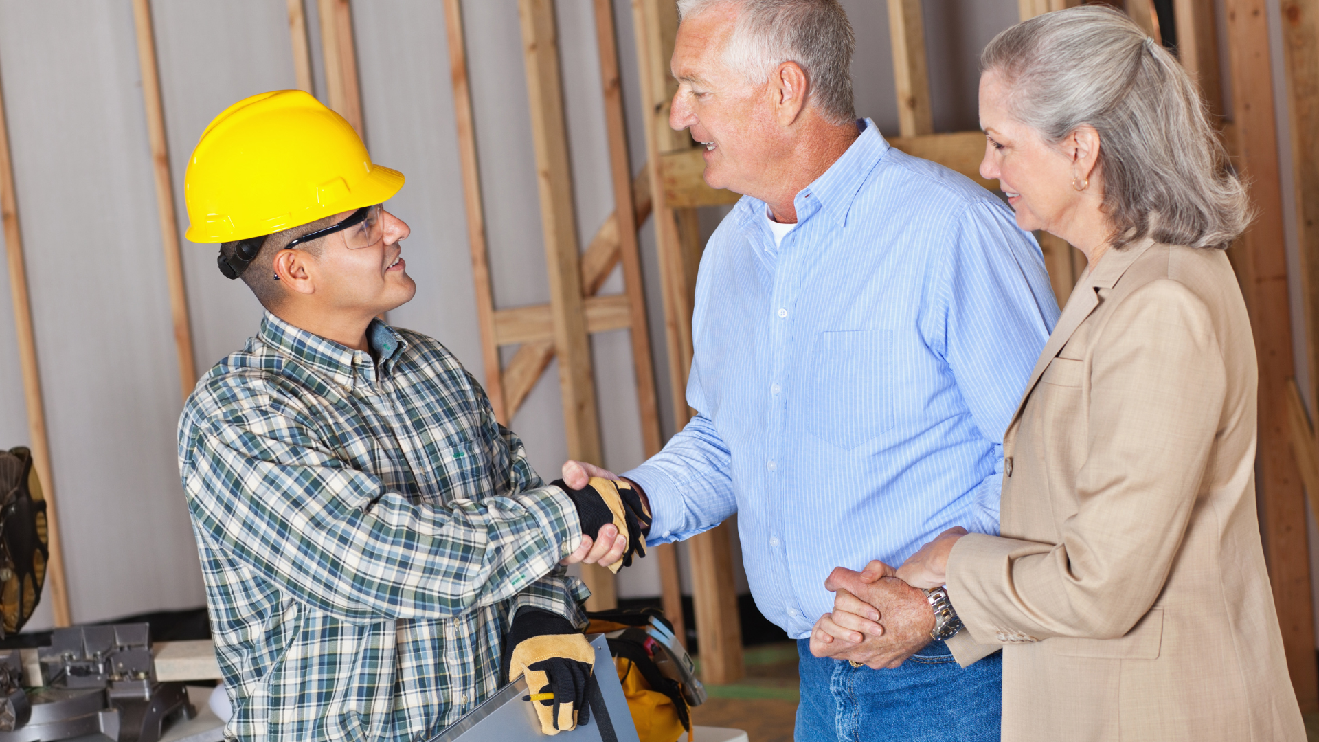 Construction worker with clients, shaking hands