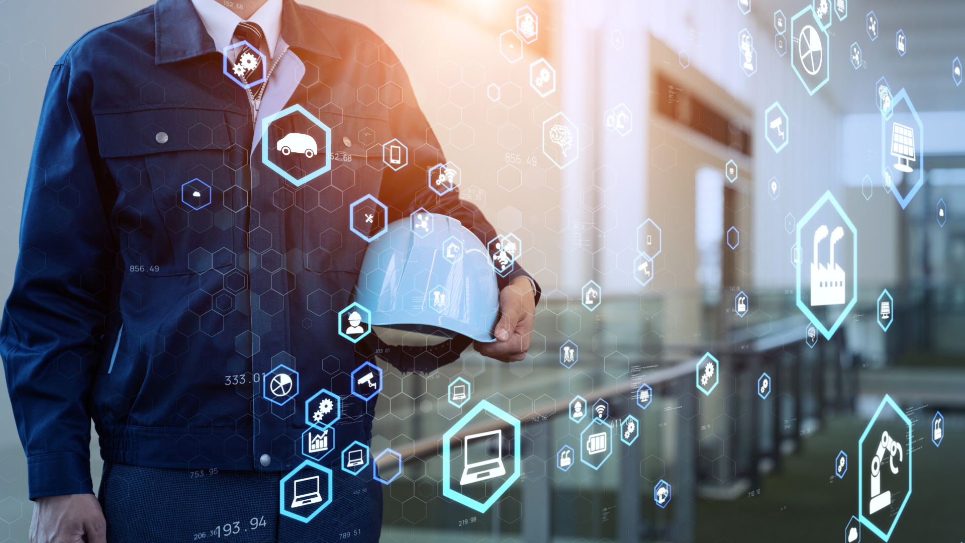 Man holding a construction hat inside of a warehouse. Graphics of digital icons overlaying the image.