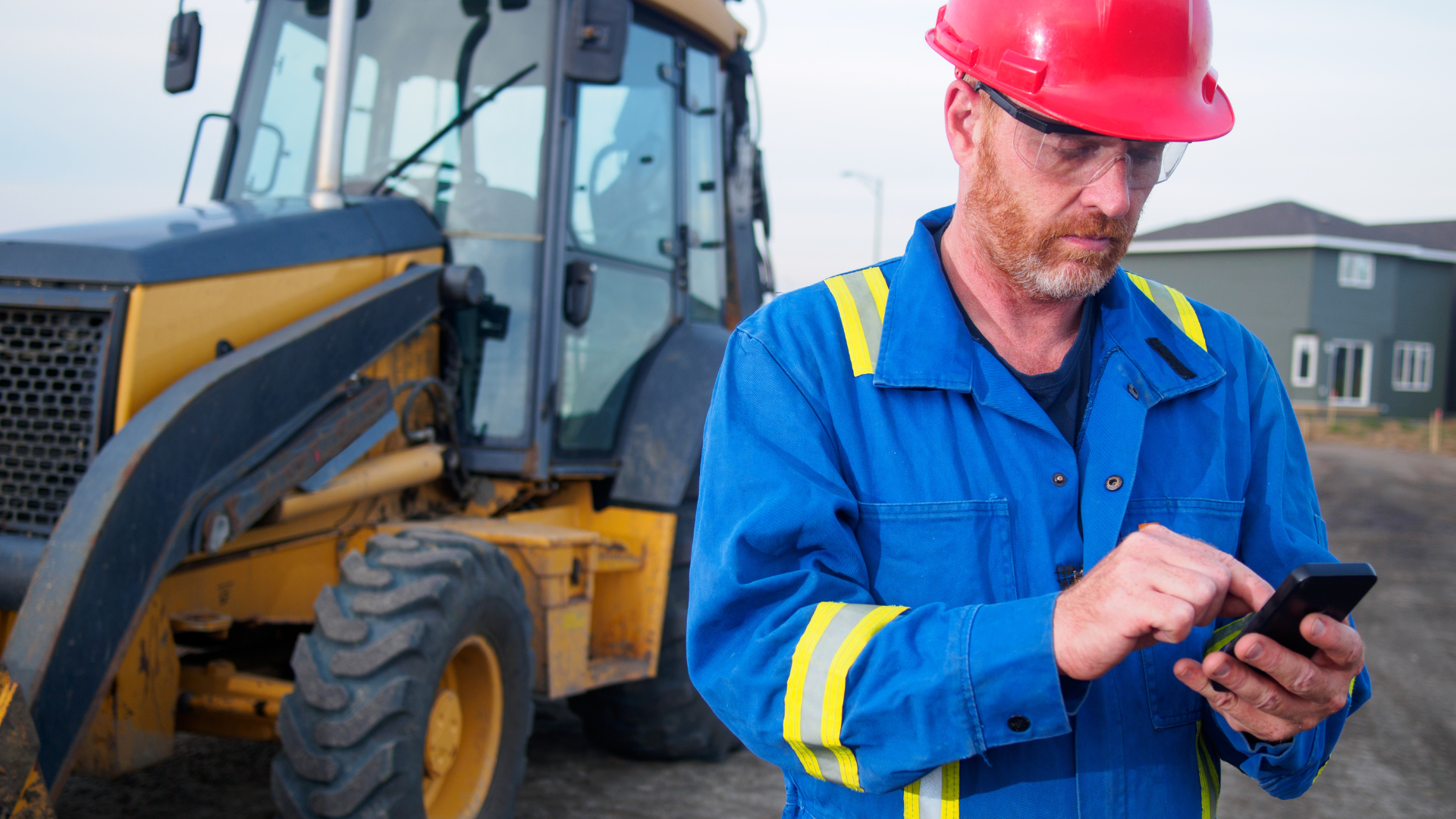 Construction worker on site checking updates on his phone