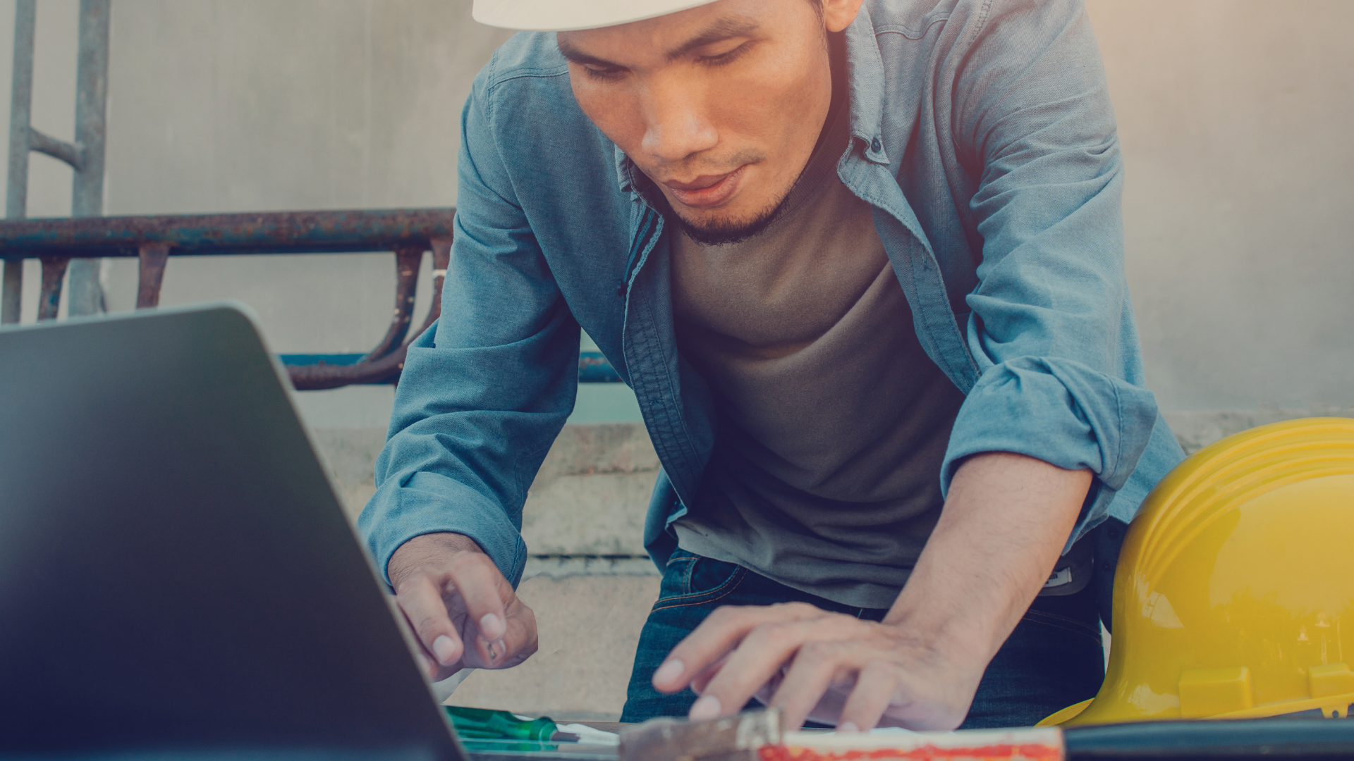 Construction worker at a site working on a laptop