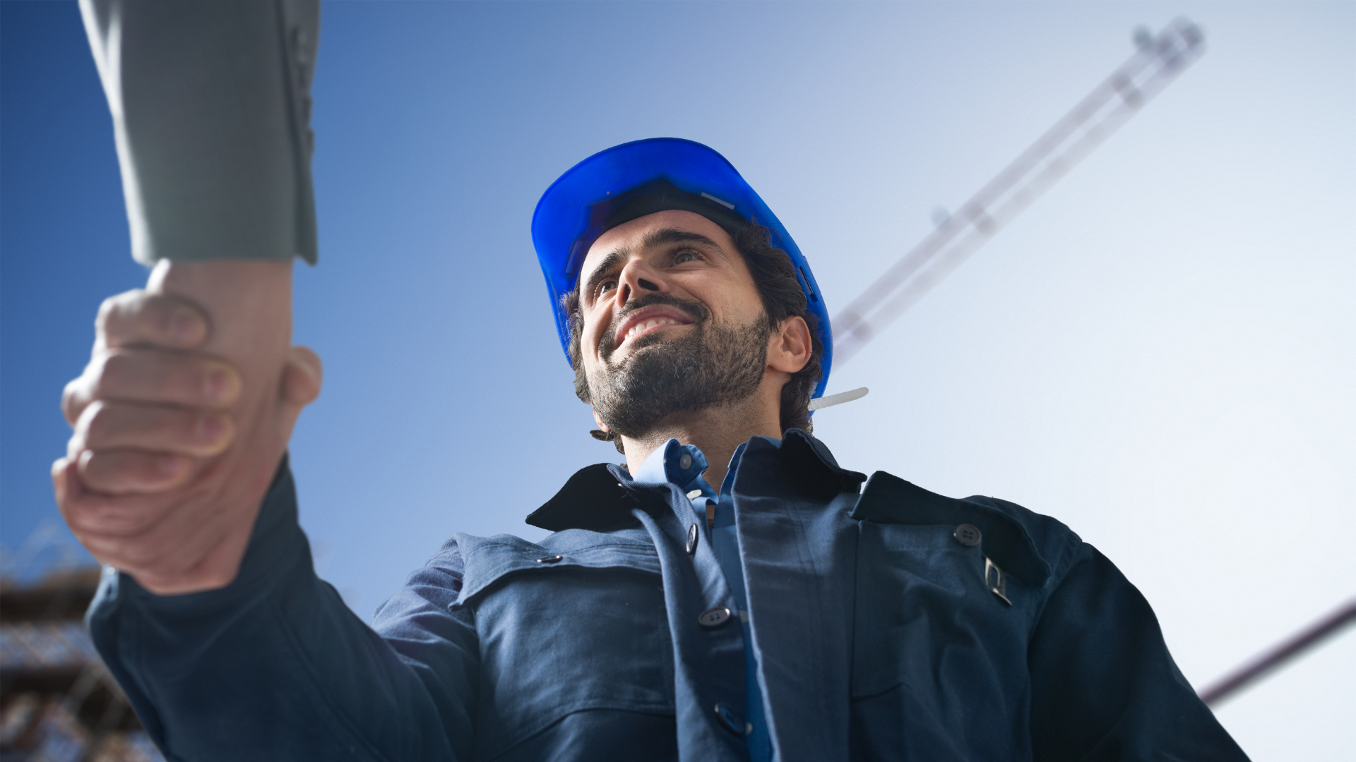 Construction worker shaking hands with a client at a work site