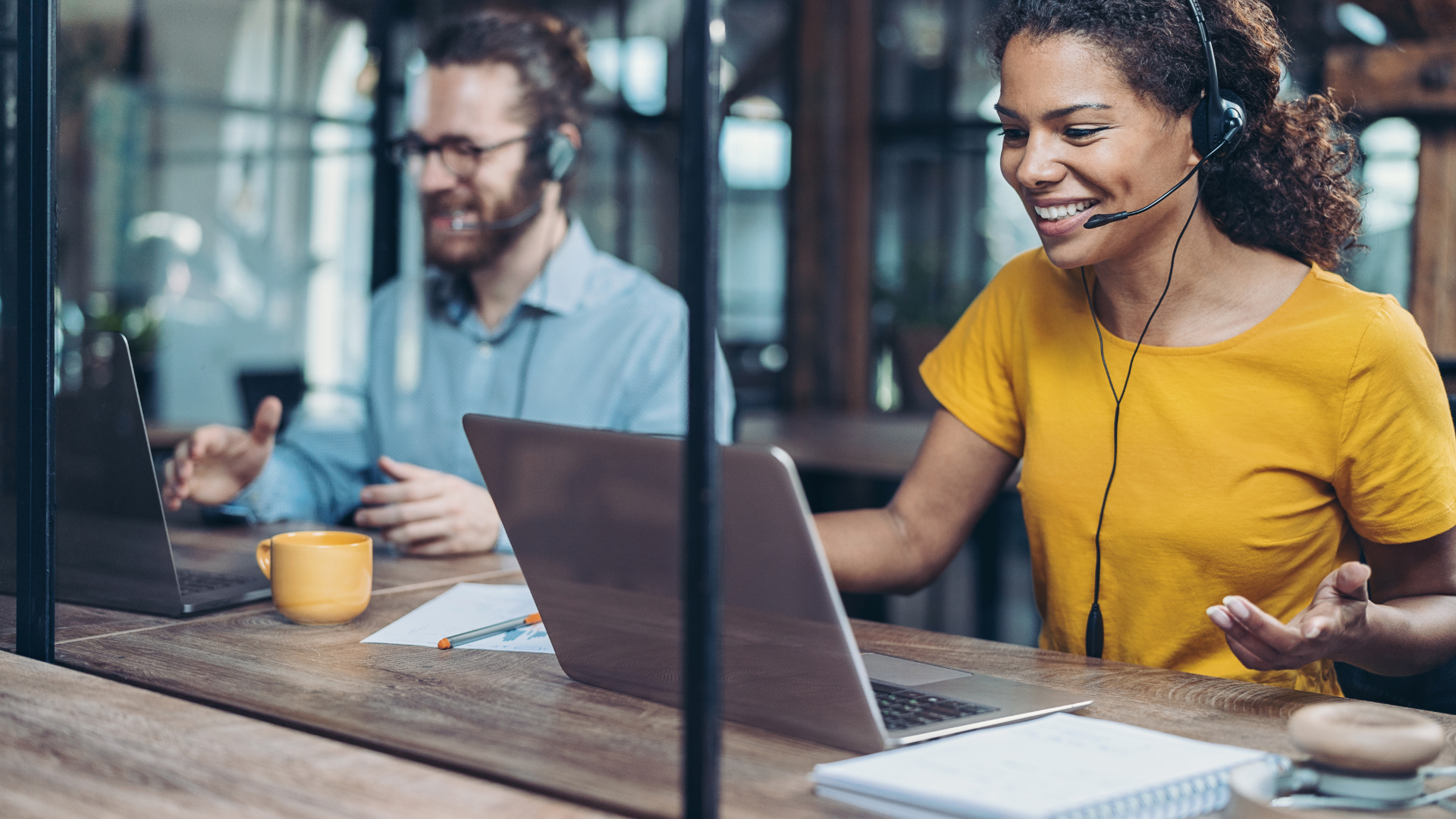 Two people in an office space working and taking calls